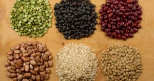 Piles of beans, rice, and lentils on a table
