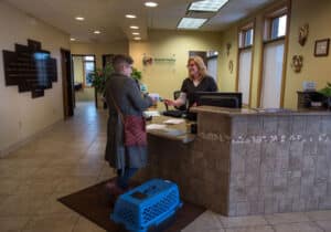 Smiling customer checking out at Grand Valley Animal Hospital front desk